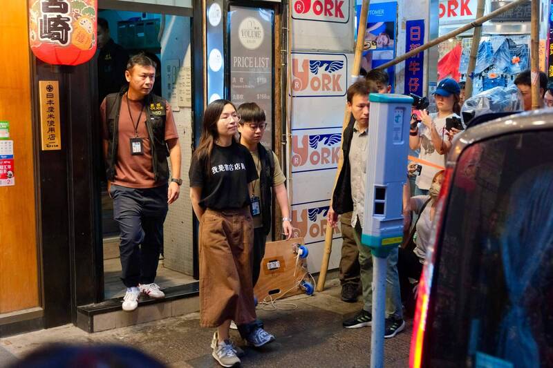 「留下书舍」一名职员15日在警方搜查后被带走。 （法新社）